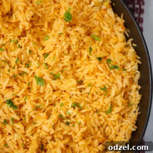 Yellow rice in a black skillet up close.