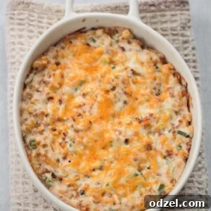 Hot cheesy corn dip served in a white baking dish, ready for dipping.