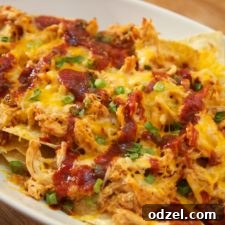 Delicious BBQ chicken nachos topped with cheese and other fresh ingredients.