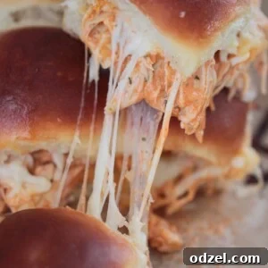 buffalo chicken sliders up close, showing melted cheese and shredded chicken.