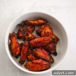 Air fryer honey BBQ wings arranged neatly on a white plate, ready to be served.
