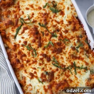 classic baked ziti in a 9x13 baking dish with cheese and red pepper flakes on the side.