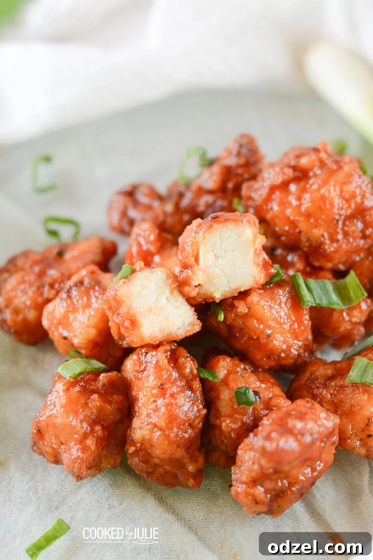 Sweet and Smoky Boneless Chicken Bites 2 honey boneless bbq wings with scallions on a green plate