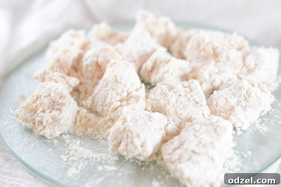 Sweet and Smoky Boneless Chicken Bites 4 chicken coated in flour on a plate