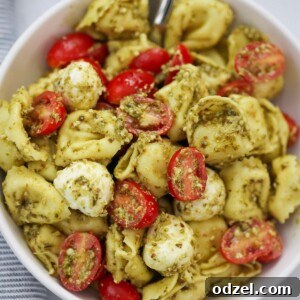 Pesto Tortellini Salad in a bowl with a spoon.