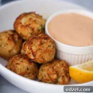 crab bites with a side of remoulade sauce and a lemon wedge.
