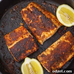 Three blackened mahi mahi fillets with lemon wedges on the side.
