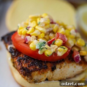 mahi mahi sandwich with corn salad on top.