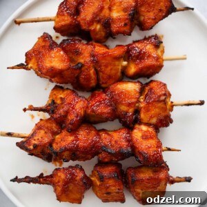 five air fryer chicken kabobs on a white plate