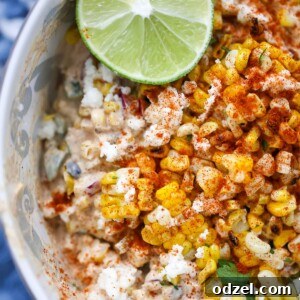 elote corn salad in a bowl with a lime on the side.