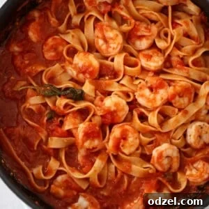 Shrimp arrabbiata with tagliatelle in a black skillet.