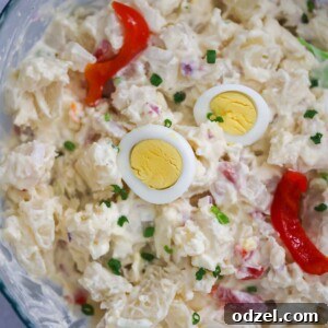Boricua Potato Bliss 2 Potato salad with boiled egg slices and pimientos on top.