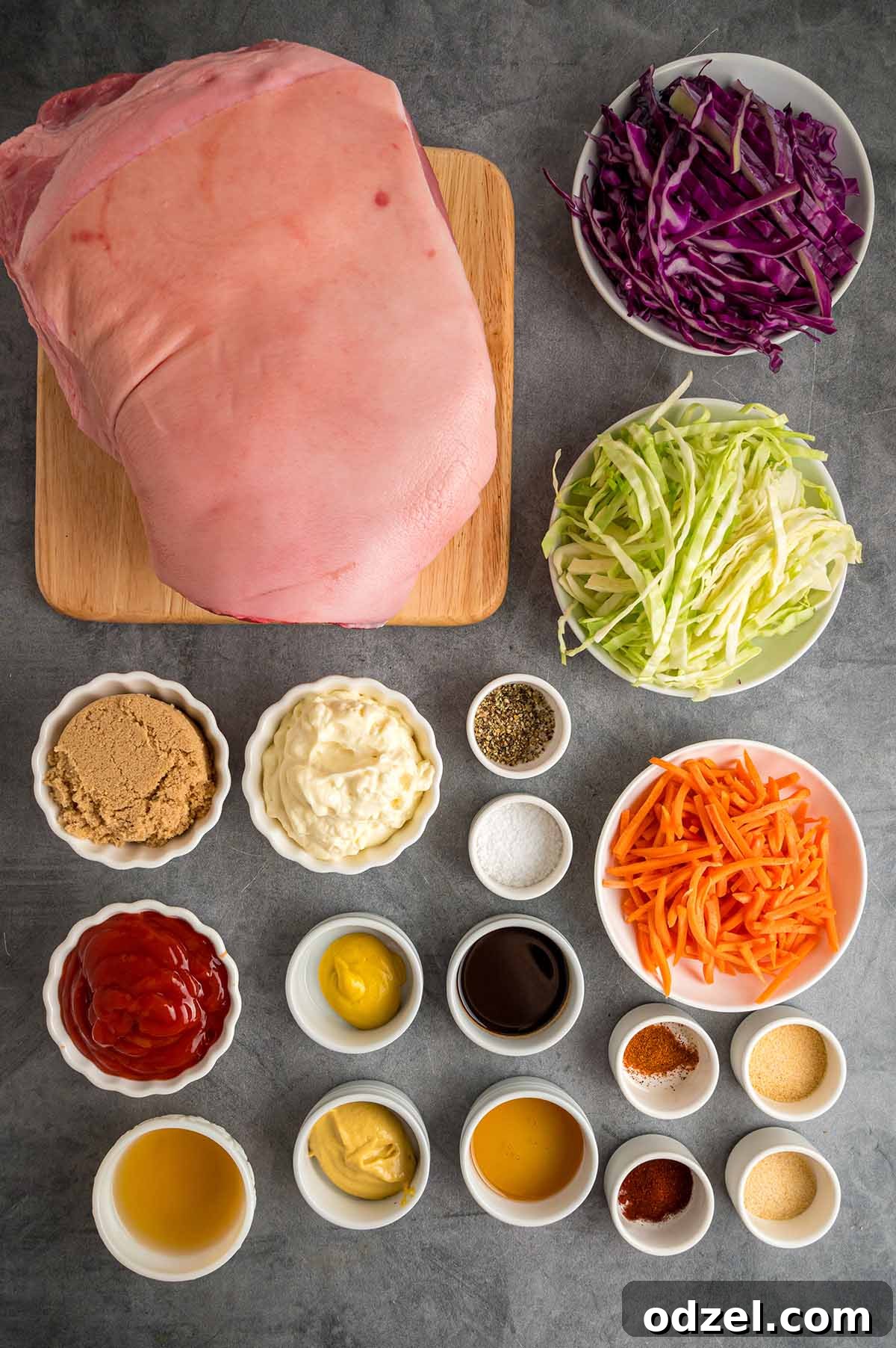 Arrangement of fresh ingredients for making pulled pork sandwiches, including pork shoulder, buns, and coleslaw components.