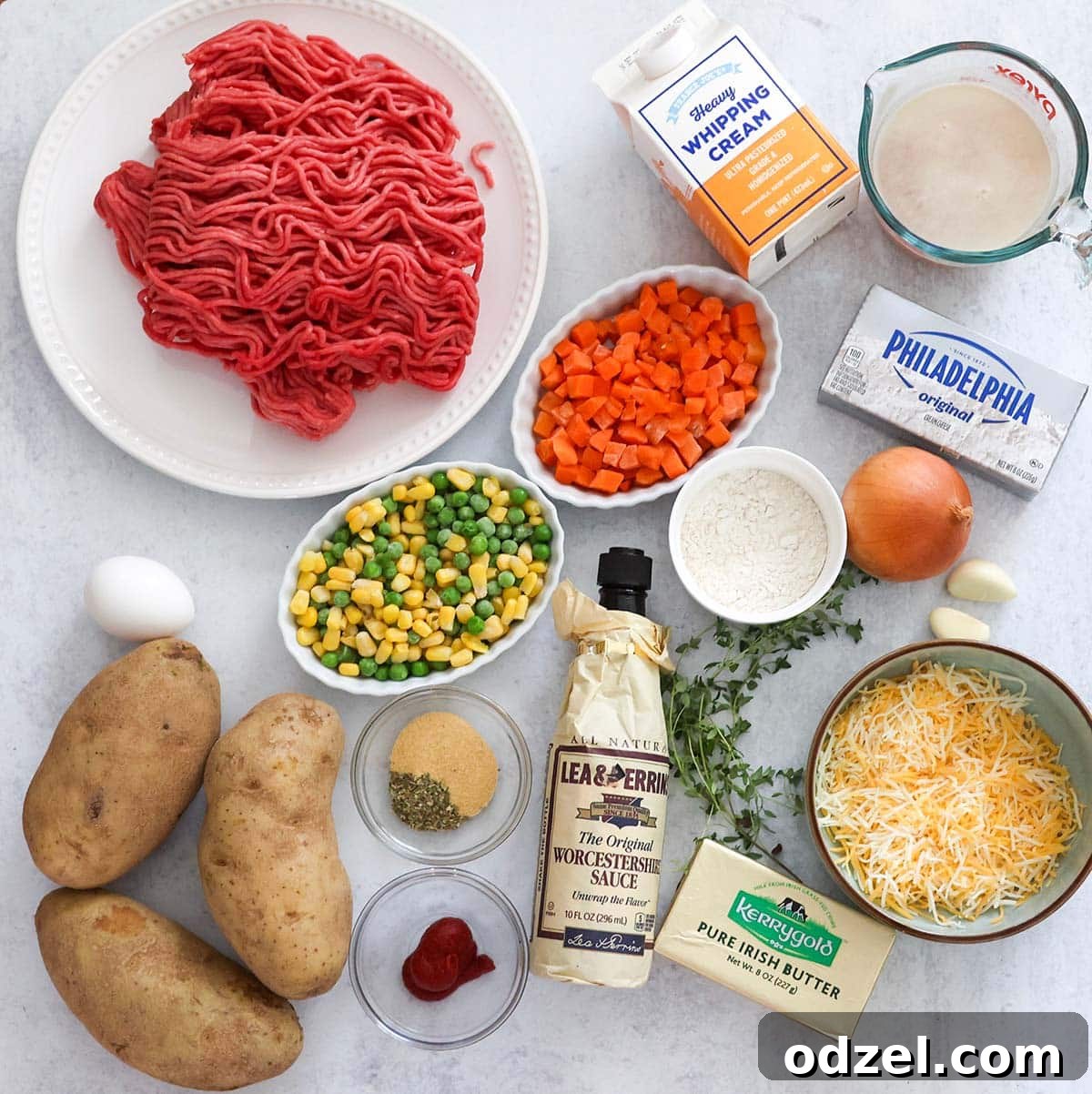 A collection of fresh ingredients neatly arranged on a counter, ready for preparing the Cottage Pie, including ground beef, potatoes, and various vegetables.
