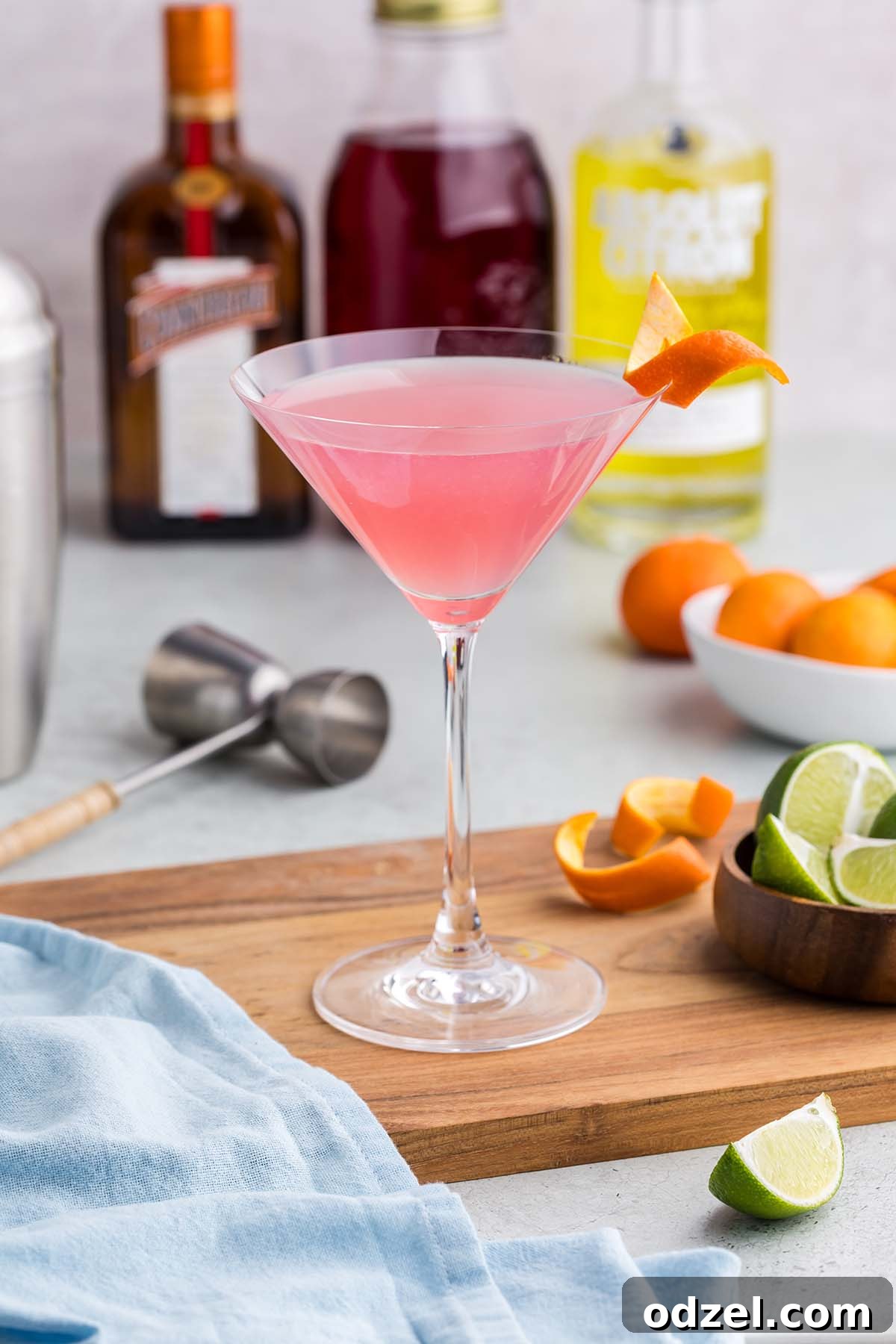A single, perfectly crafted Cosmopolitan martini, garnished with a citrus twist, in a close-up shot.
