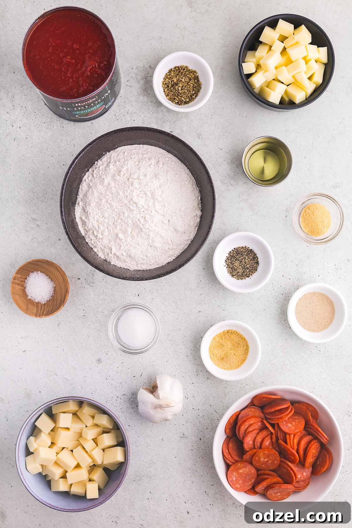 Ingredients for making Detroit-style pizza laid out on a wooden surface.