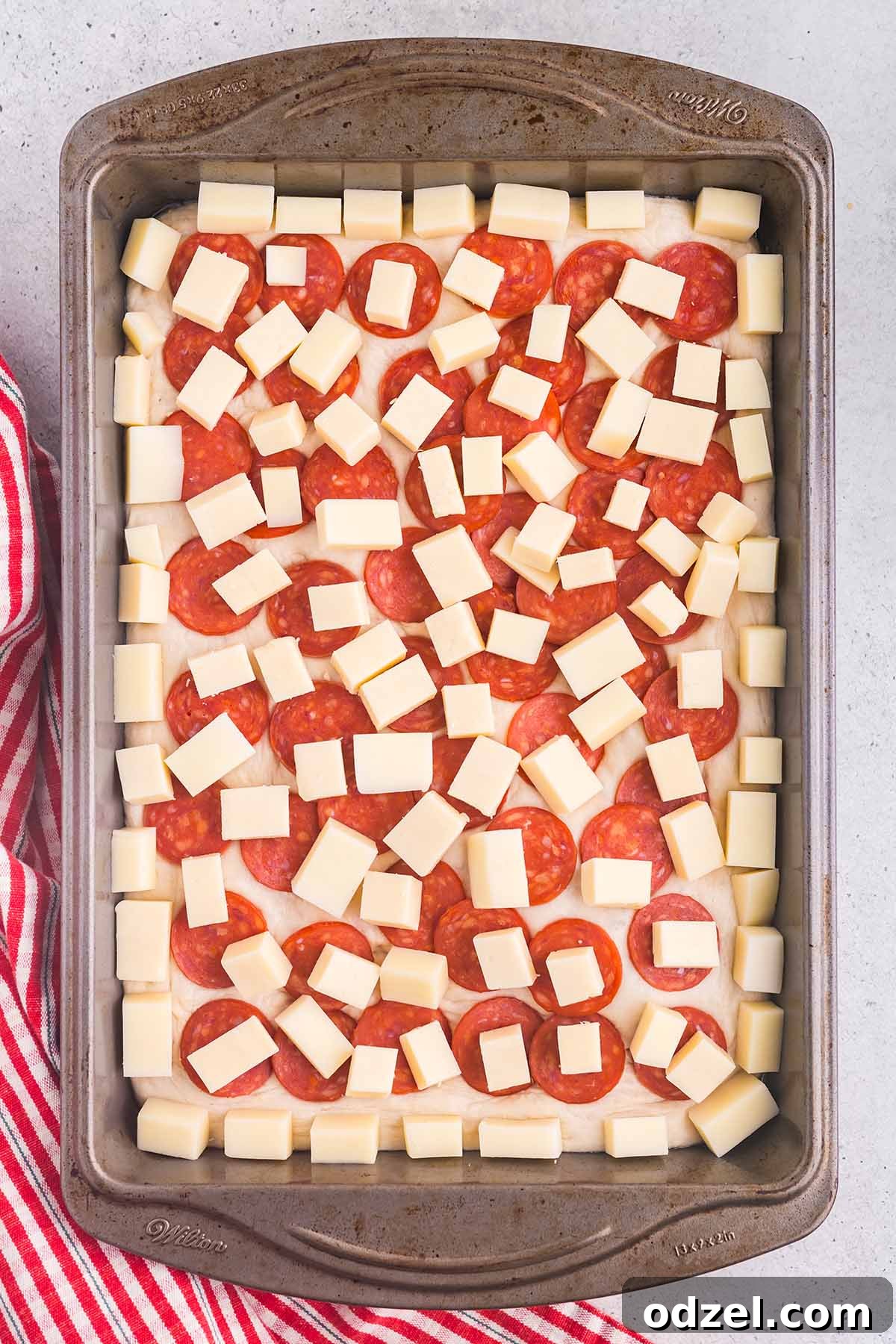 A close-up shot of a Detroit-style pizza featuring various toppings, fresh and vibrant.