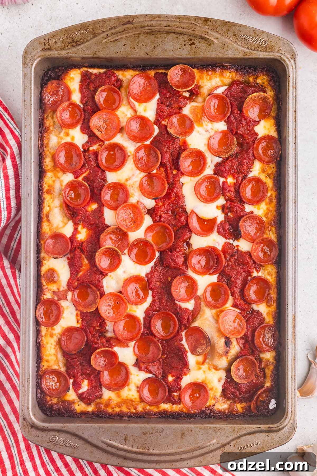 A large 9x13 Detroit-style pizza with pepperoni, freshly baked and golden.