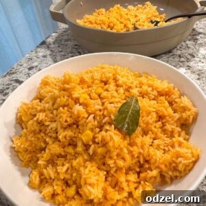 A white bowl filled with fluffy red Mexican rice garnished with a sprig of cilantro.