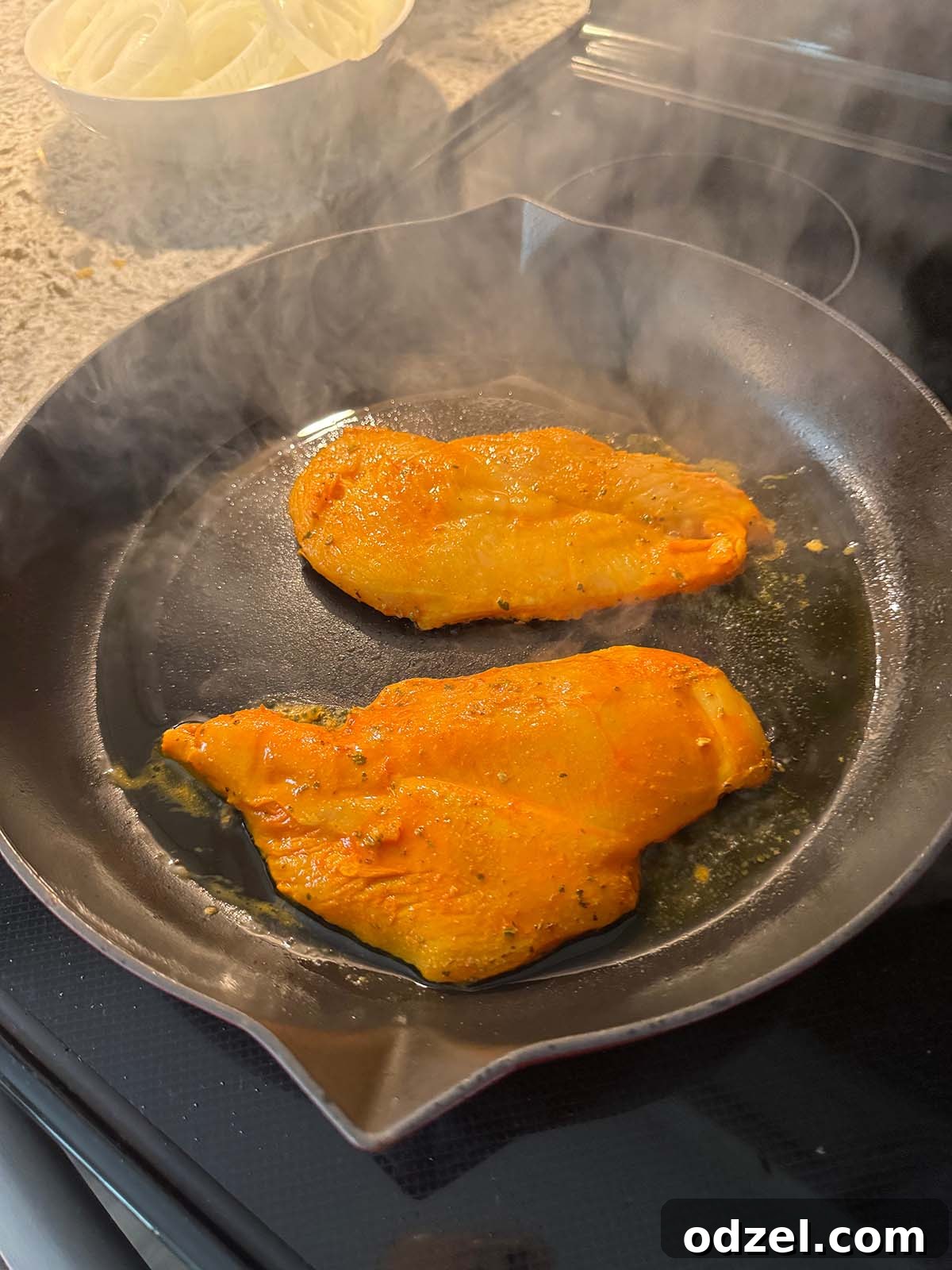 Pollo a la Plancha chicken searing in a hot cast iron skillet, developing a golden-brown crust.