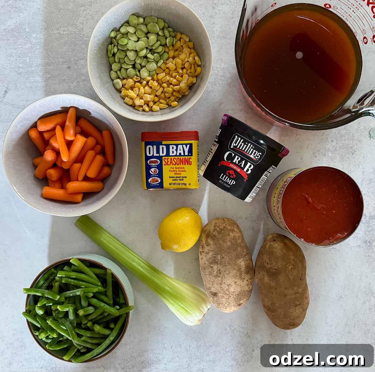 Key ingredients for Maryland crab soup including fresh lump crab meat, beef stock, an assortment of vegetables, potatoes, lemon, crushed tomatoes, and Old Bay seasoning.