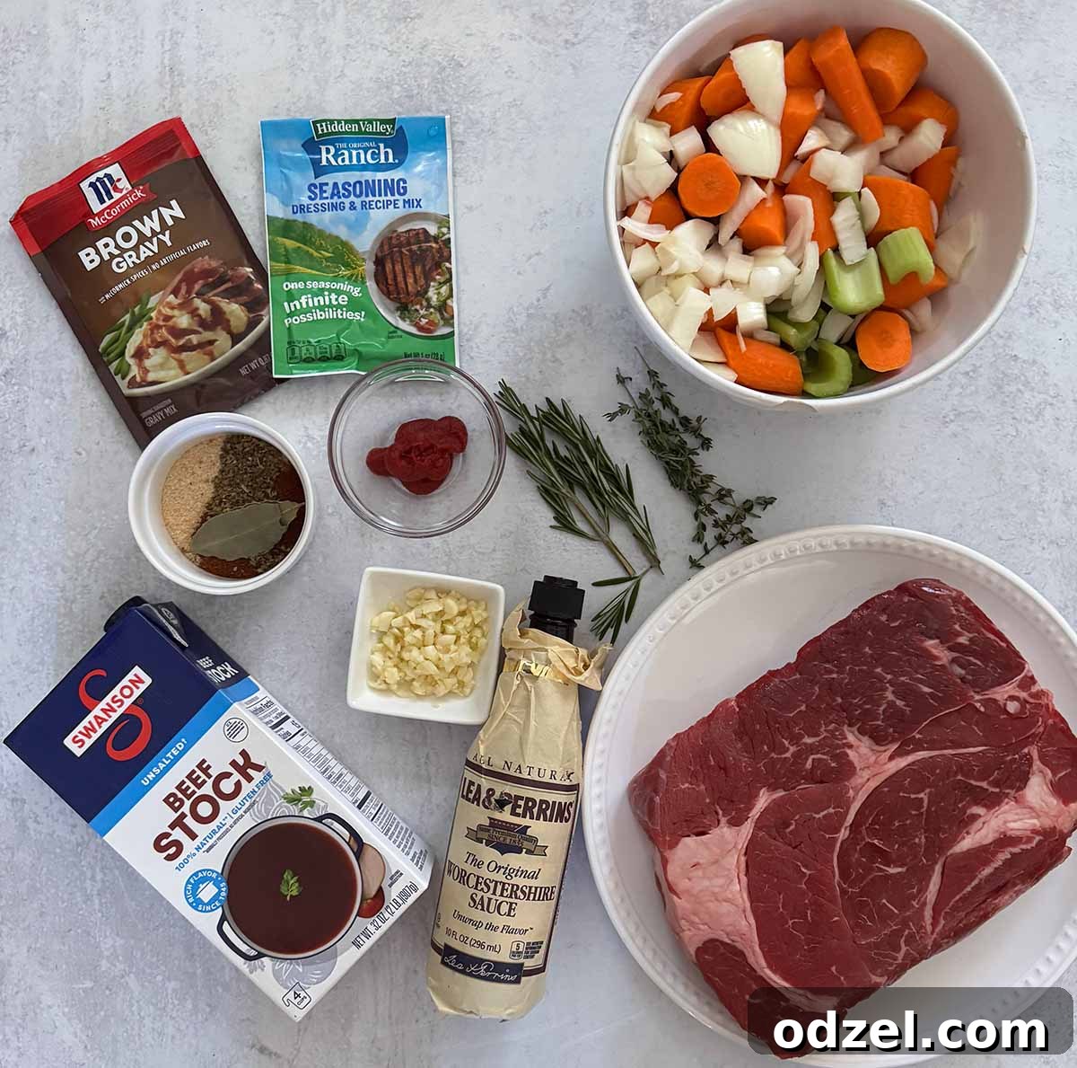 Tender Slow Cooker Pot Roast with Creamy Goat Cheese Mashed Potatoes 3 A selection of fresh ingredients including a boneless chuck roast, diced onions, carrots, celery, minced garlic, herbs like rosemary and thyme, and various seasonings, all prepared for a slow cooker pot roast.