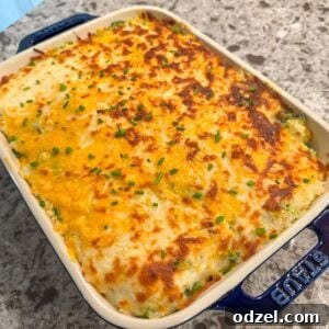 A close-up of the delicious cheesy broccoli rice casserole in a blue baking dish, garnished with fresh herbs.