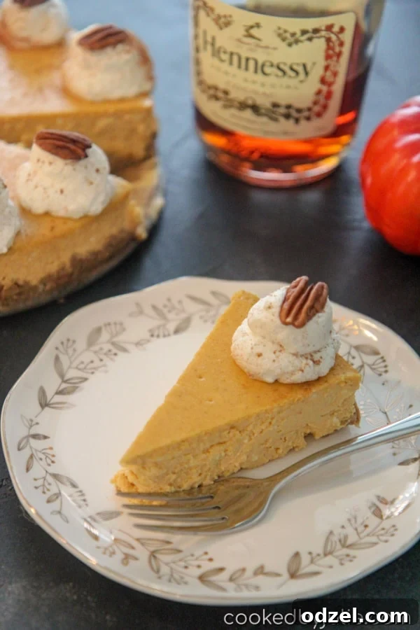 Decadent Cognac Pumpkin Cheesecake 2 A perfectly sliced pumpkin cognac cheesecake showing its creamy texture, golden crust, and a dollop of whipped cream with pecans, ready to be enjoyed.
