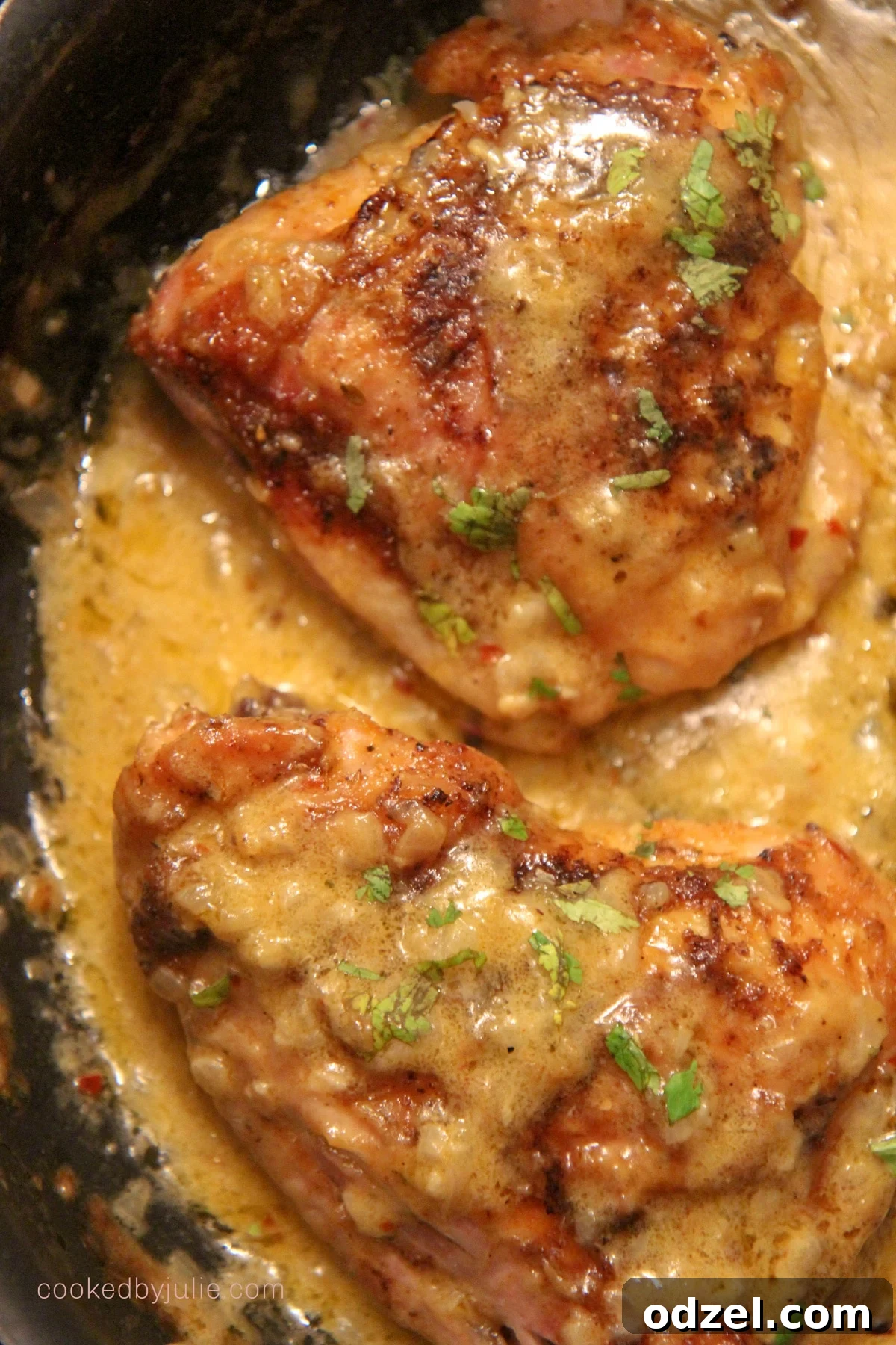 Dreamy Creamed Chicken Thighs 3 Two creamy smothered chicken thighs in a black cast iron skillet