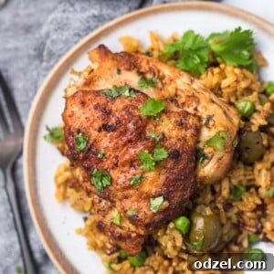A beautifully plated serving of Arroz con Pollo Cubano, showcasing the golden rice and tender chicken.