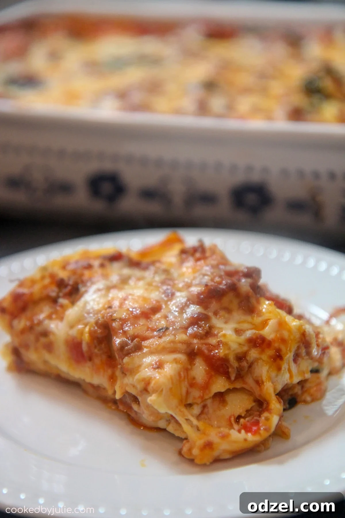 Spicy Bayou Lasagna 3 A perfectly portioned slice of Cajun Lasagna on a white plate, showcasing its layers of cheese and meat sauce.