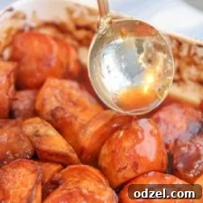 Spoon drizzling candy glaze over baked candied yams in a circular motion, showcasing the rich, sweet topping.