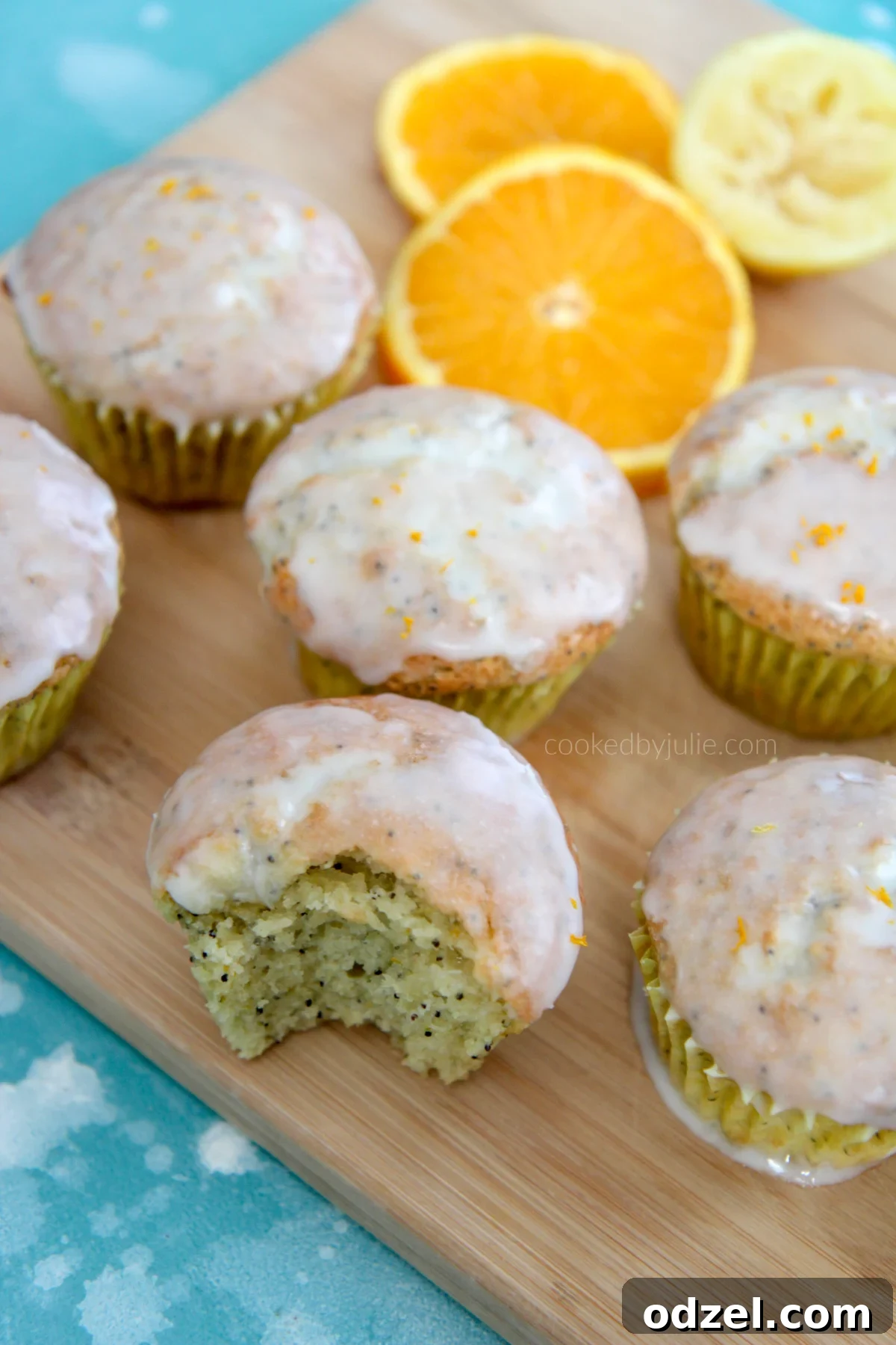 Delicious orange lemon poppy seed muffins beautifully arranged on a rustic wooden board, garnished with fresh orange slices and poppy seeds, ready to be enjoyed.