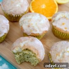 orange lemon poppy seed muffins on a wooden board with orange slices