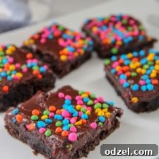 brownies with rainbow chips on top of a white plate