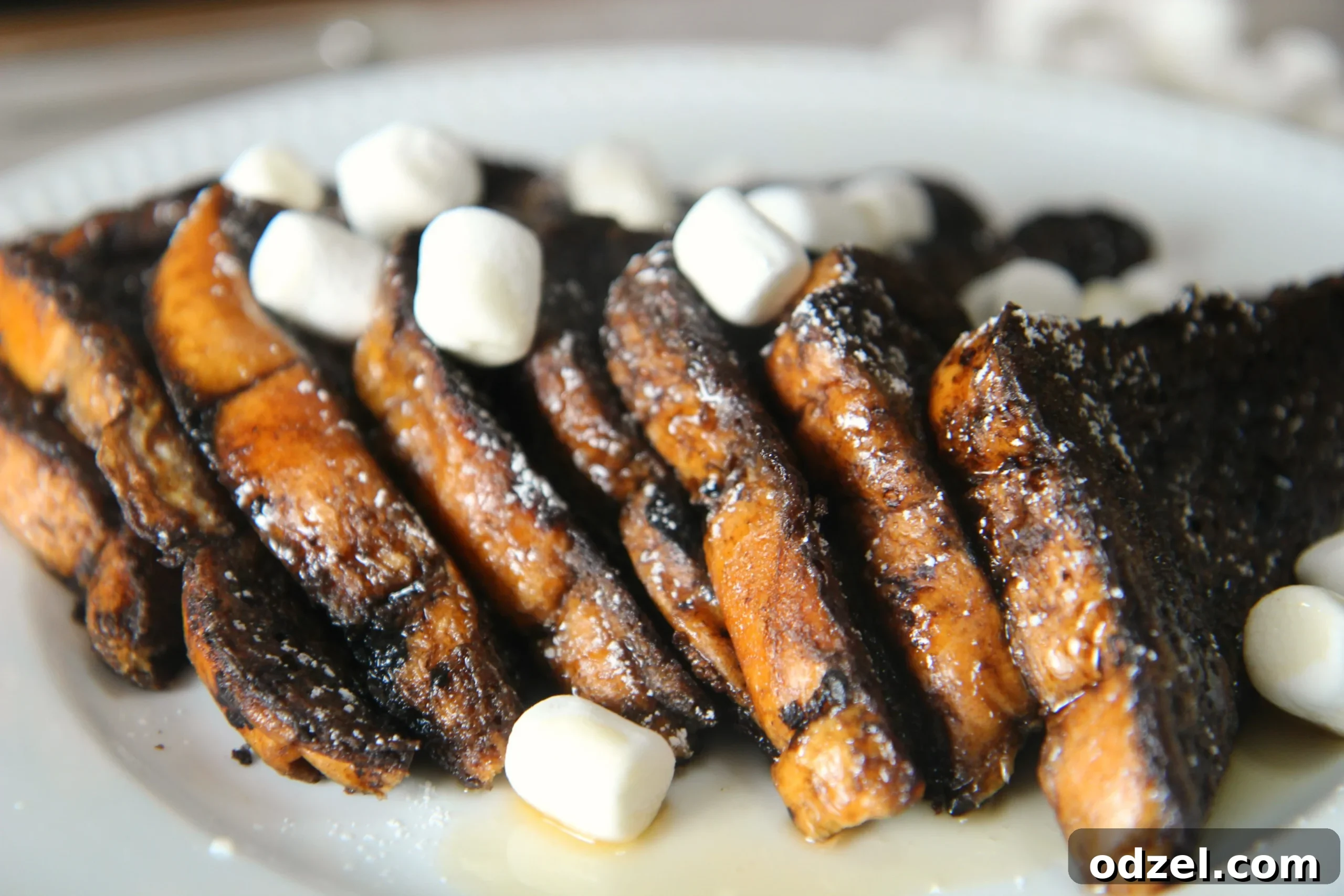 Warm Hot Chocolate French Toast topped with melted marshmallows and chocolate syrup, a perfect dessert-like breakfast.