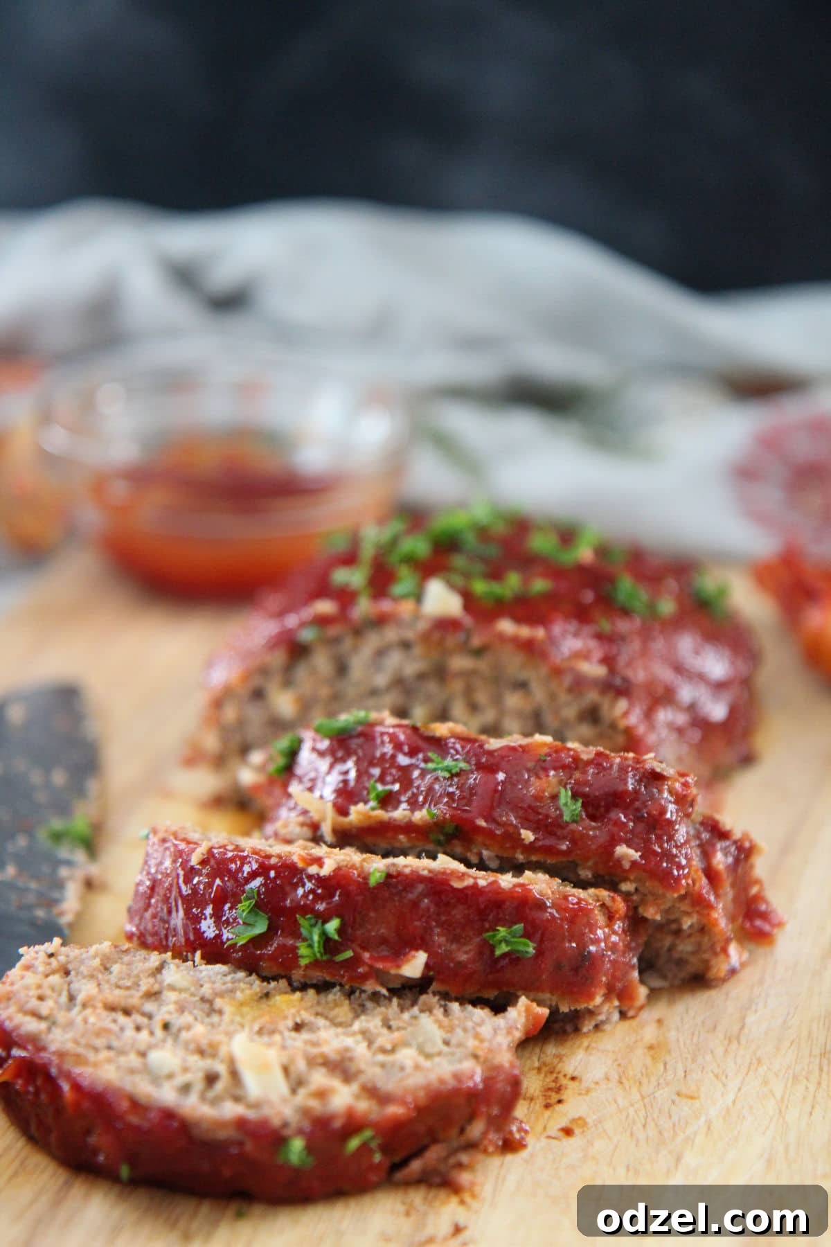 slices of turkey meatloaf on a wooden board with ketchup on the side