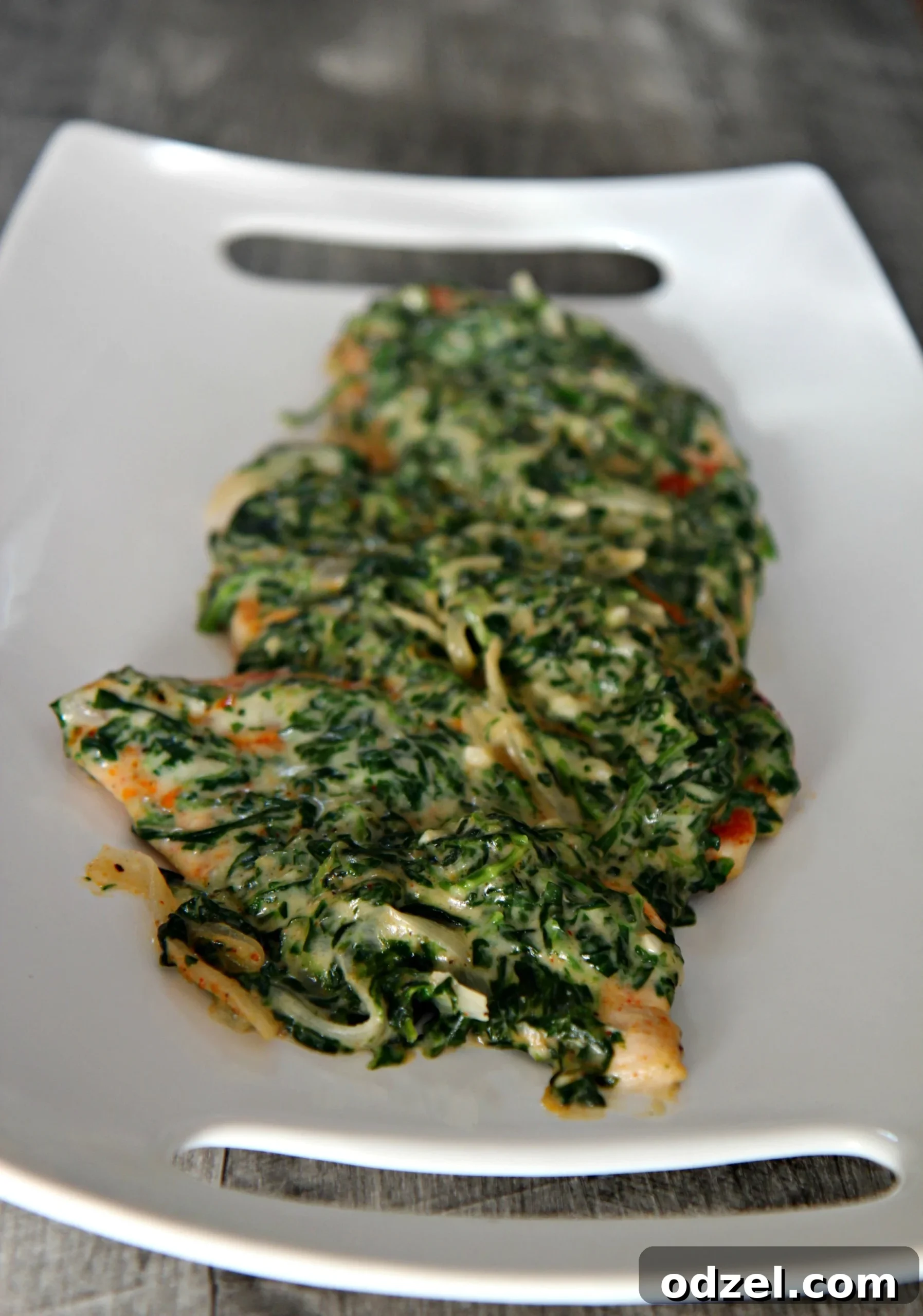 Golden-seared chicken breast resting on a bed of rich, creamy spinach sauce, ready to be served