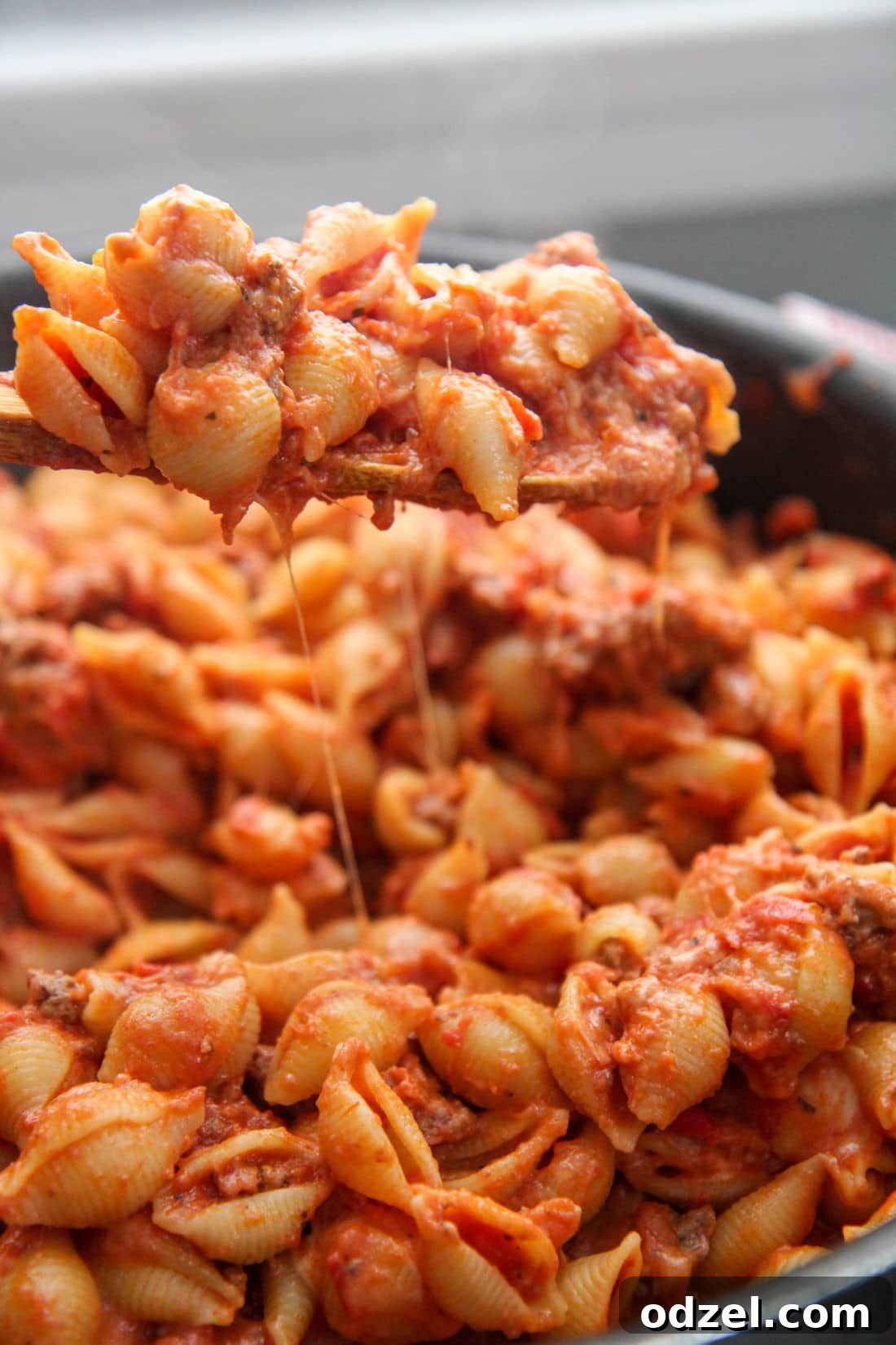Heartwarming Beef Shells 2 a spoonful of creamy beef and shells over a skillet