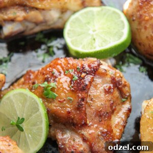 Bone-in chicken thighs cooked in a cast iron skillet with lime wedges