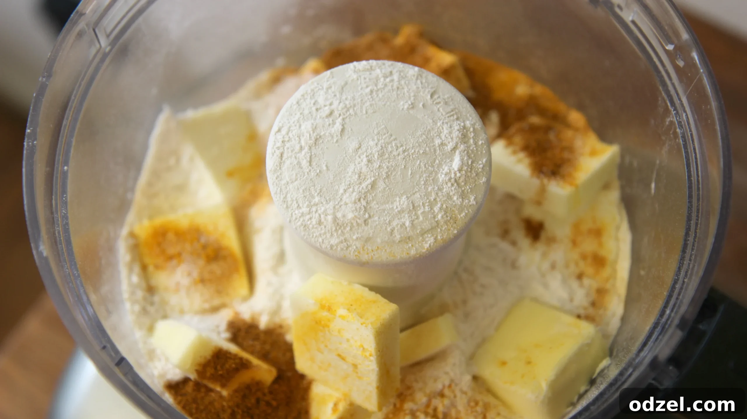 A close-up view of wet and dry ingredients being blended in a food processor, forming a cohesive dough.