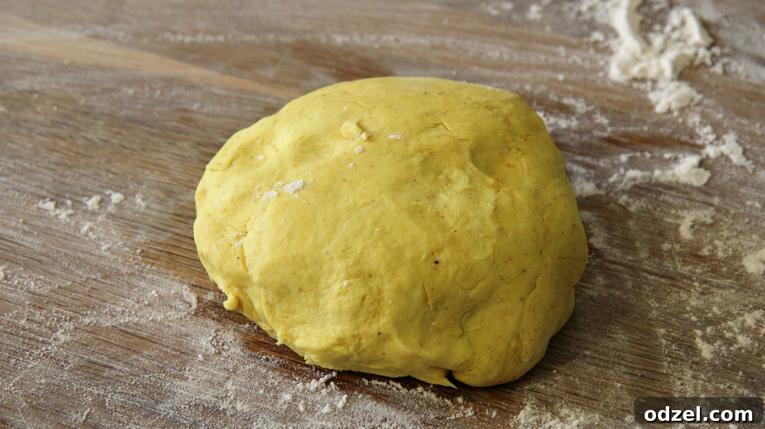 A smooth, round ball of vibrant yellow dough, indicating the proper consistency before refrigeration.