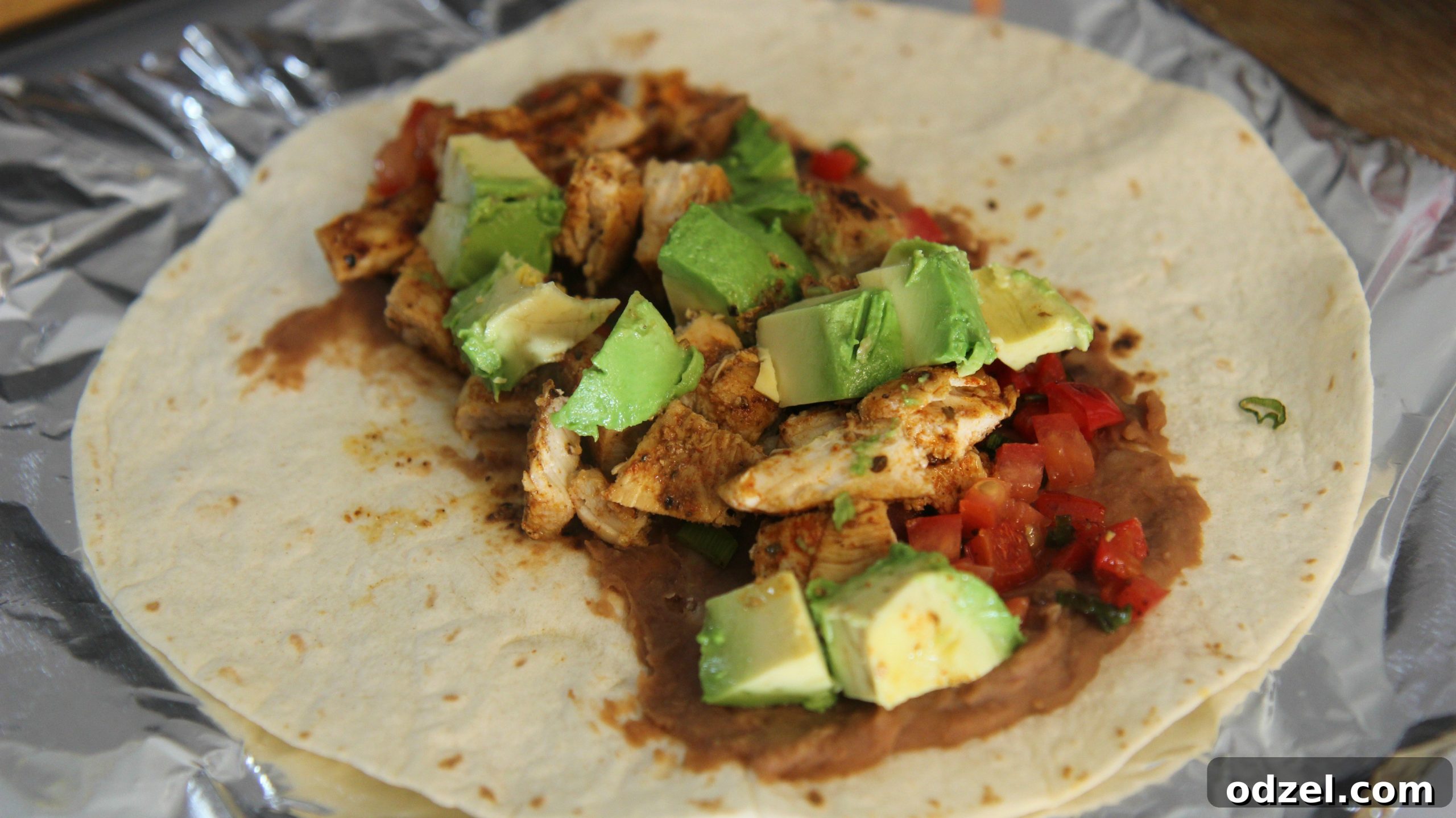 Signature Grilled Tex-Mex Chicken Burrito 6 Add the chicken to a tortilla with refried beans, avocado chunks and some tomatoes.