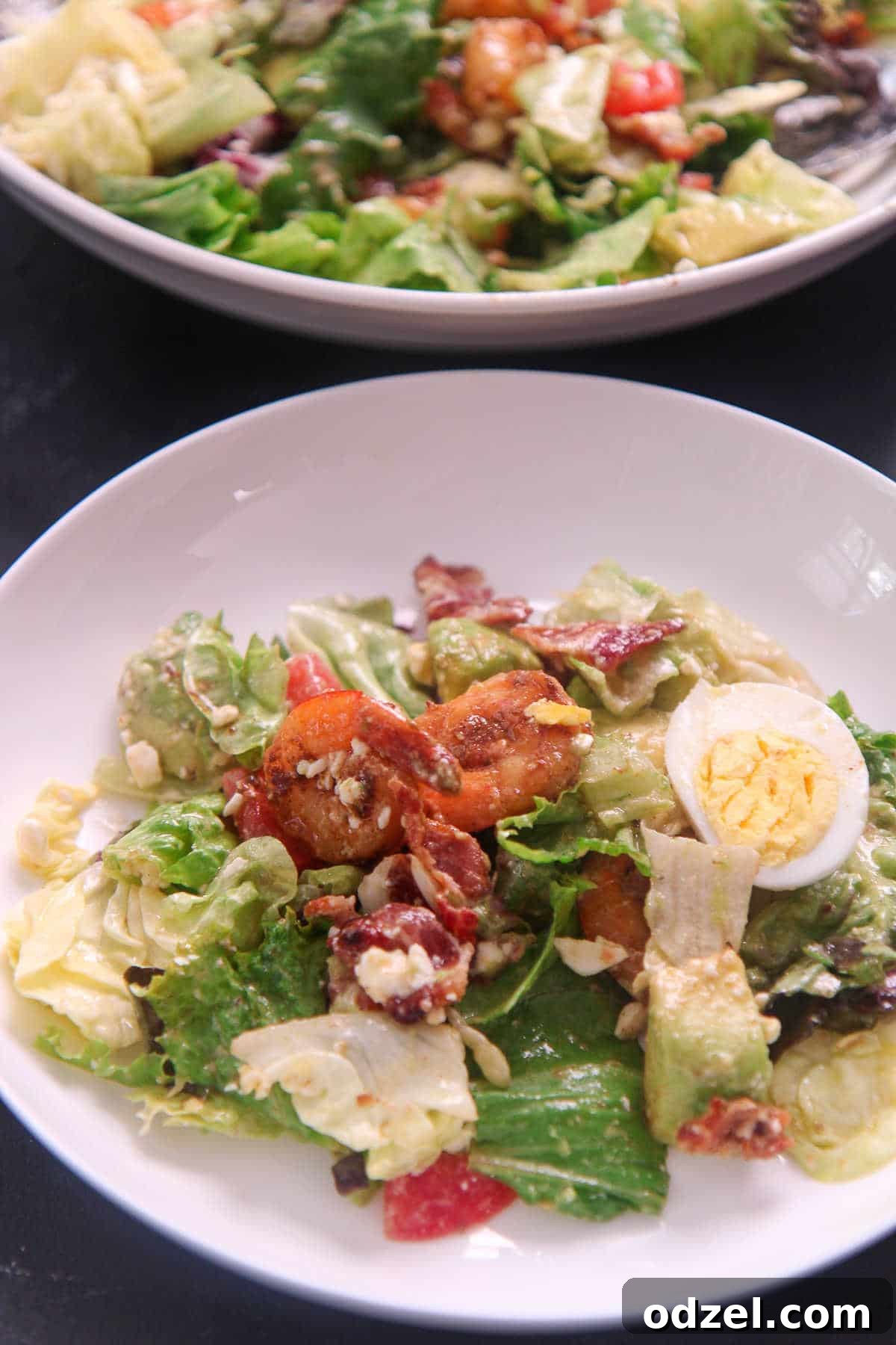 Vibrant Shrimp Cobb 3 a small plate of shrimp cobb salad with a fork and bowl in the background