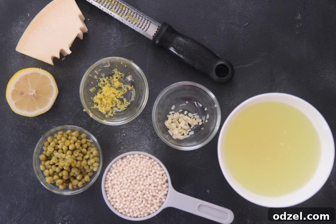 chicken stock, couscous, peas, lemon, garlic, and cheese in individual bowls 