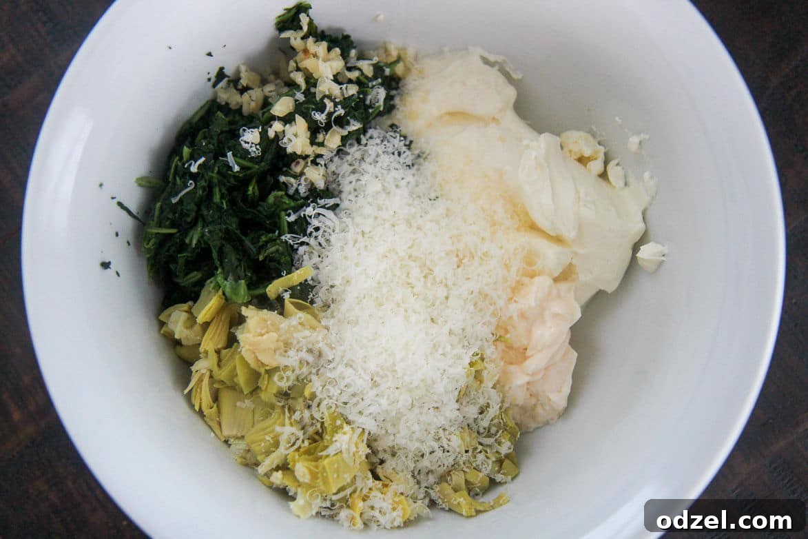 spinach, cheese, and artichokes in a white bowl