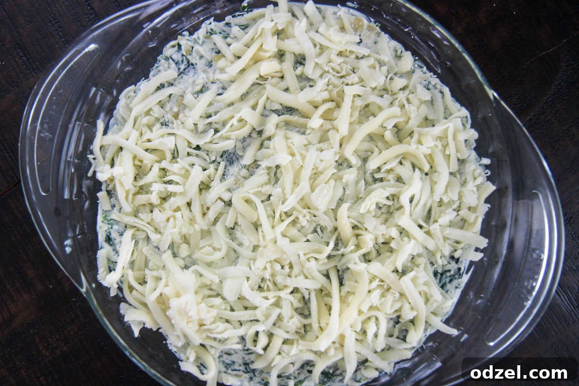 spinach dip with mozzarella cheese in a glass dish