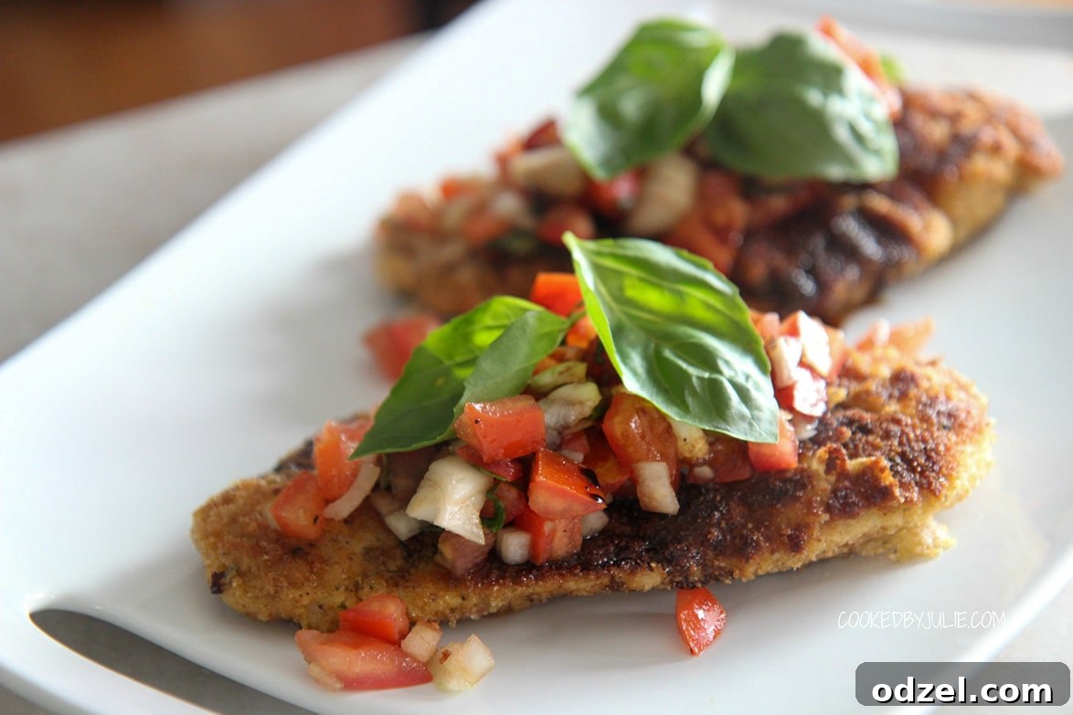 Tuscan Chicken Bruschetta 5 Two elegantly plated servings of crispy chicken bruschetta, each topped generously with fresh tomato, onion, and basil, and drizzled with balsamic glaze, on a clean white plate ready to be enjoyed.