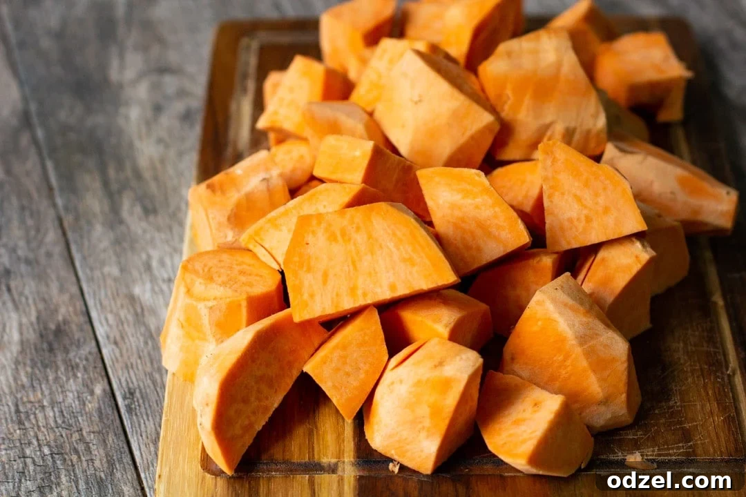 Golden Sweet Potato Bliss 3 Peeled and chopped sweet potatoes on a wooden cutting board