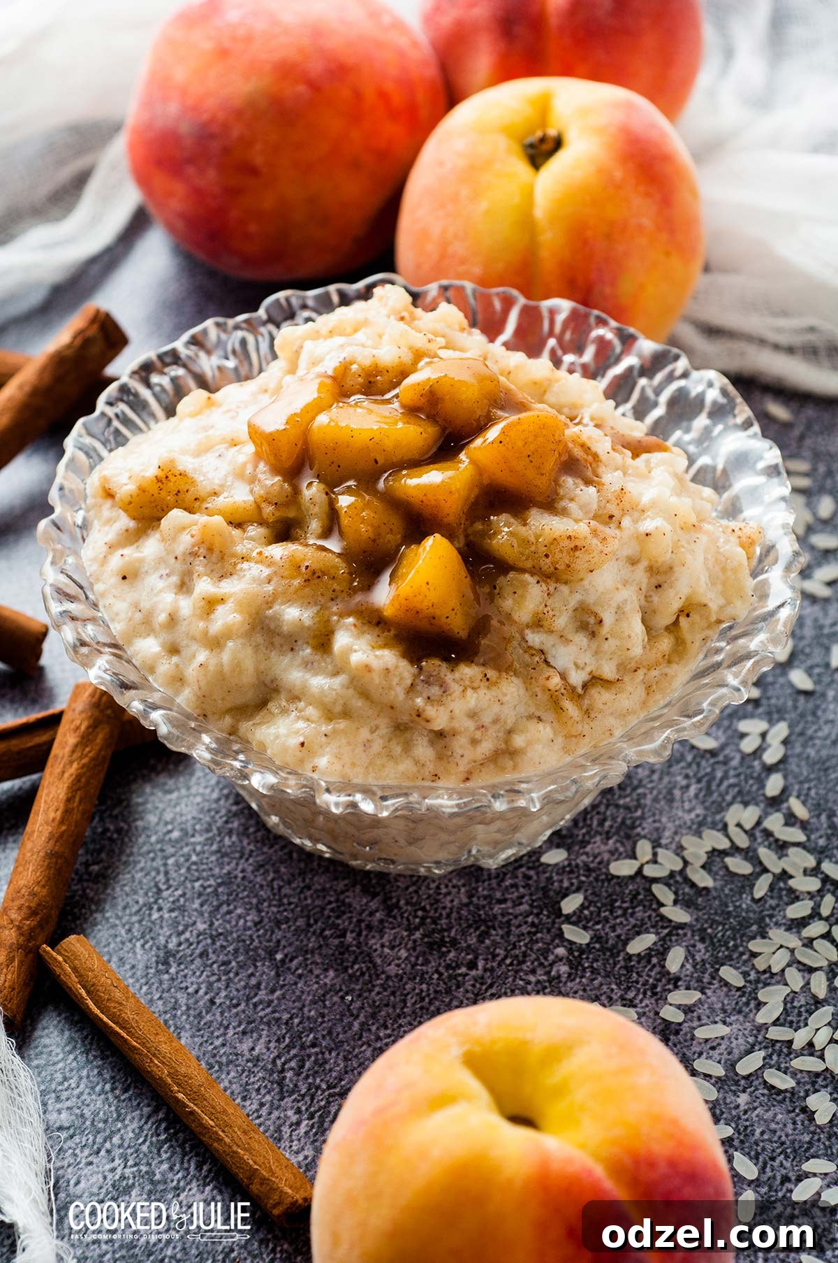 Sun-Kissed Peach Rice Pudding 2 Rich baked rice pudding topped with fresh peaches in a glass bowl, with extra peaches arranged on the side